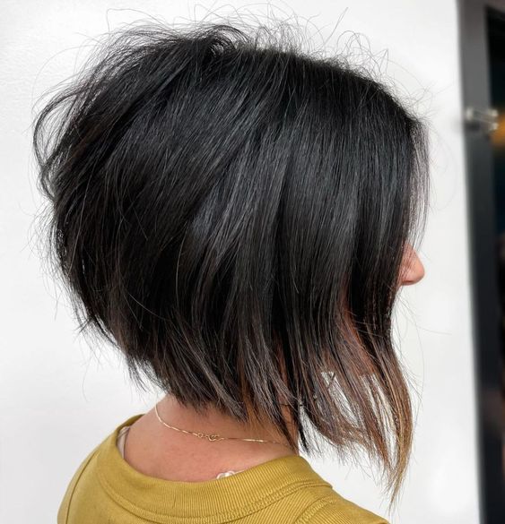 Cabelo curto e escuro, estilo bob, com pontas mais longas na frente, sobre fundo branco.