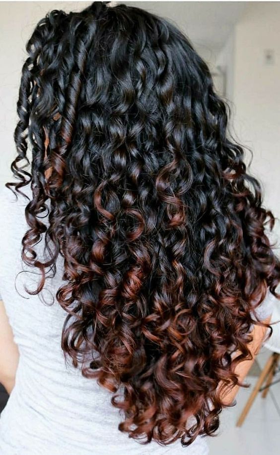 balayage-pinterest Cabelo longo e cacheado, com tons castanhos e avermelhados, visto de costas.